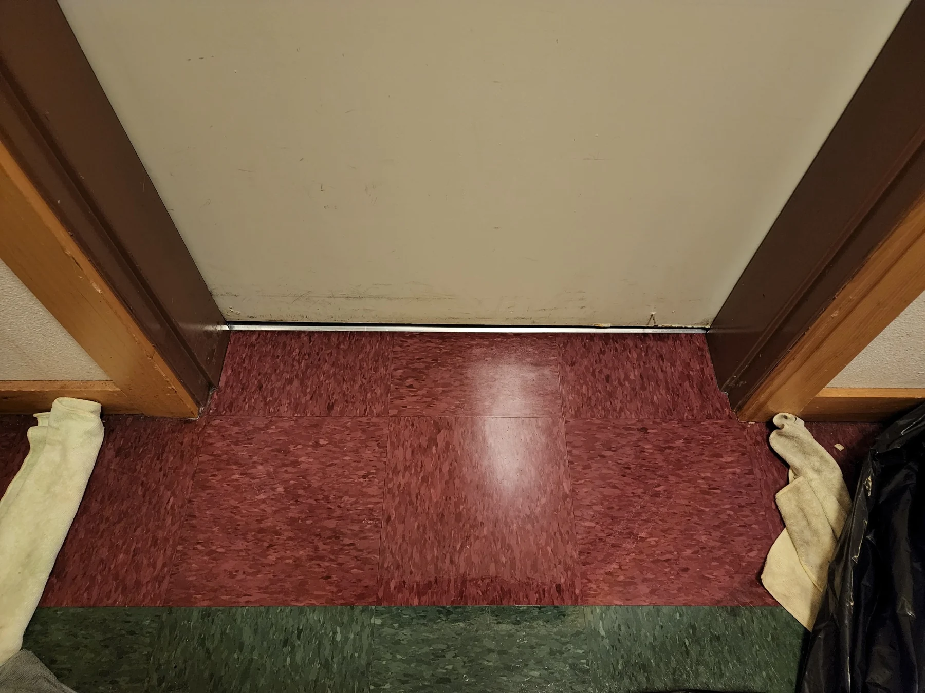 Burgundy carpet flooring in doorway with dark wood frame and cream ceiling