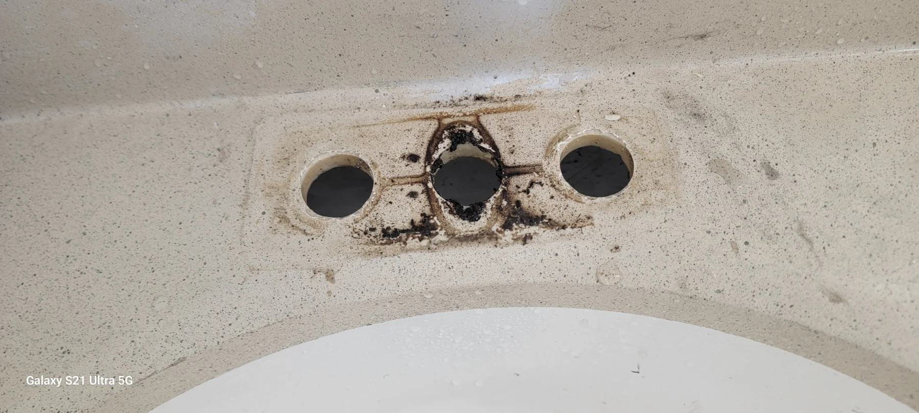 Ceiling with three circular holes and deteriorating plaster around damaged center hole